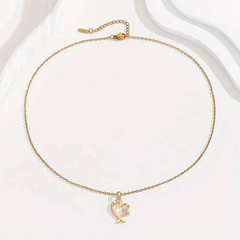 Gold necklace with a heart-shaped pendant on a white background