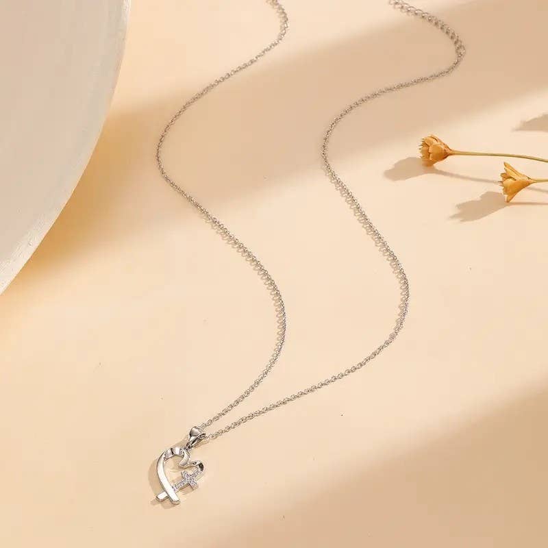 Silver necklace with a heart-shaped pendant on a beige background