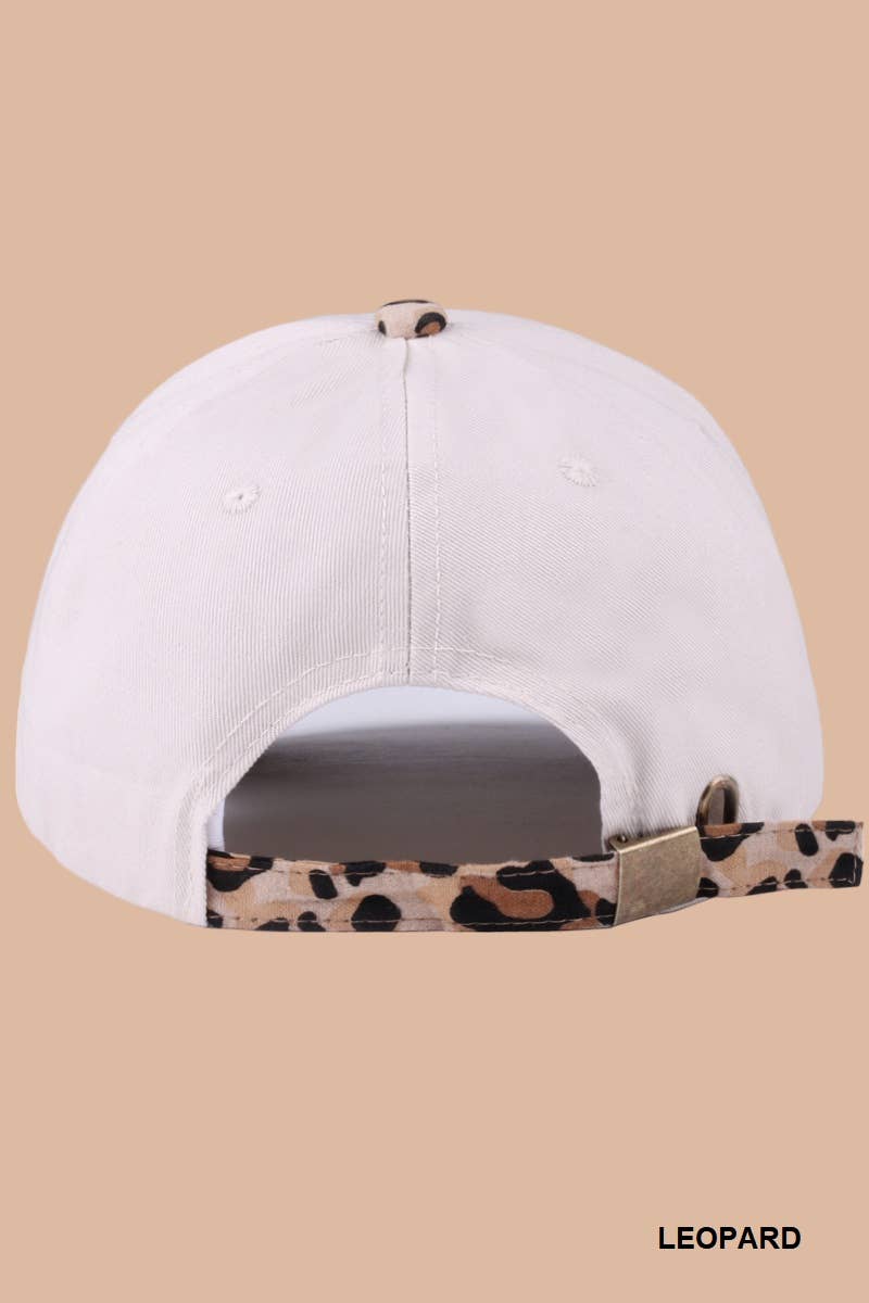 White cap with leopard print brim on a beige background